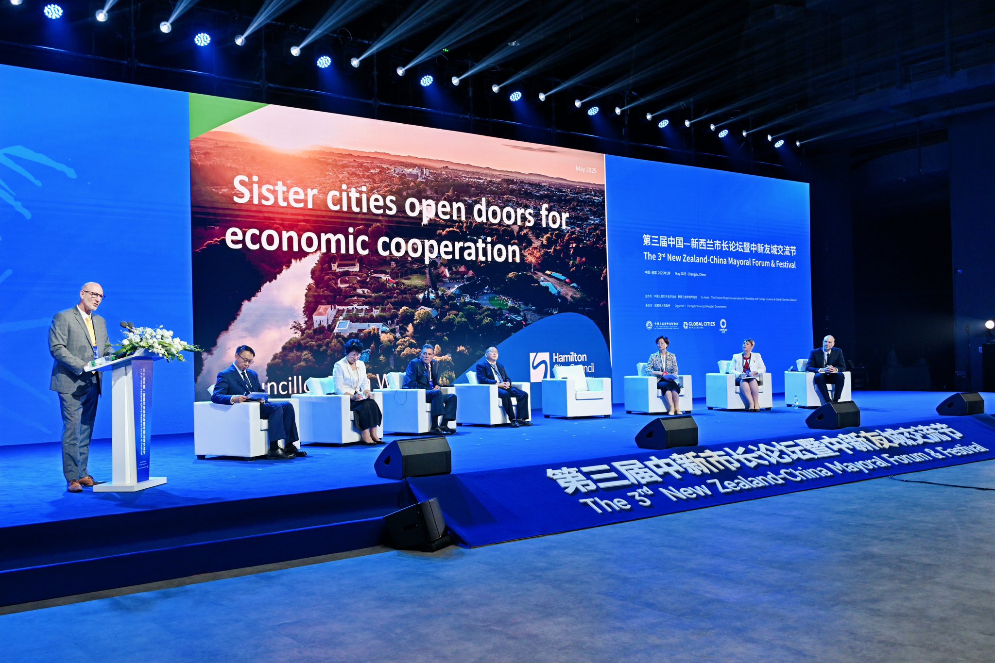Speaker at a podium on stage at a sister cities economic cooperation conference