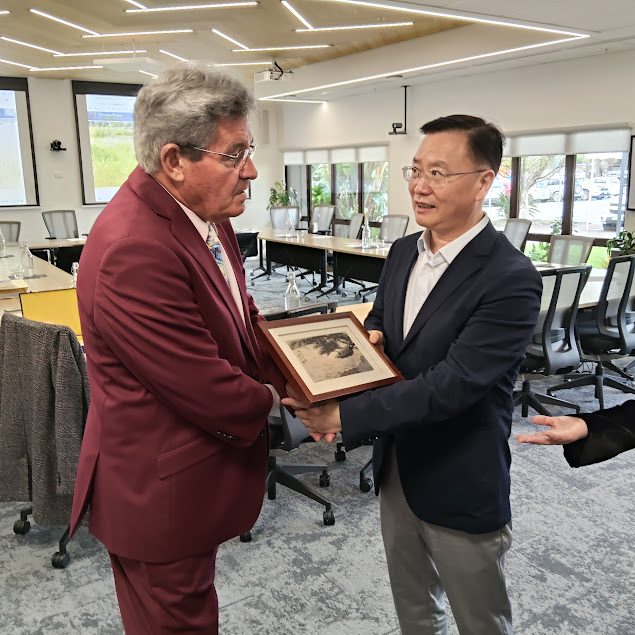 A New Zealand mayor exchanges gifts with a visiting partner-city deputy mayor at a civic welcome